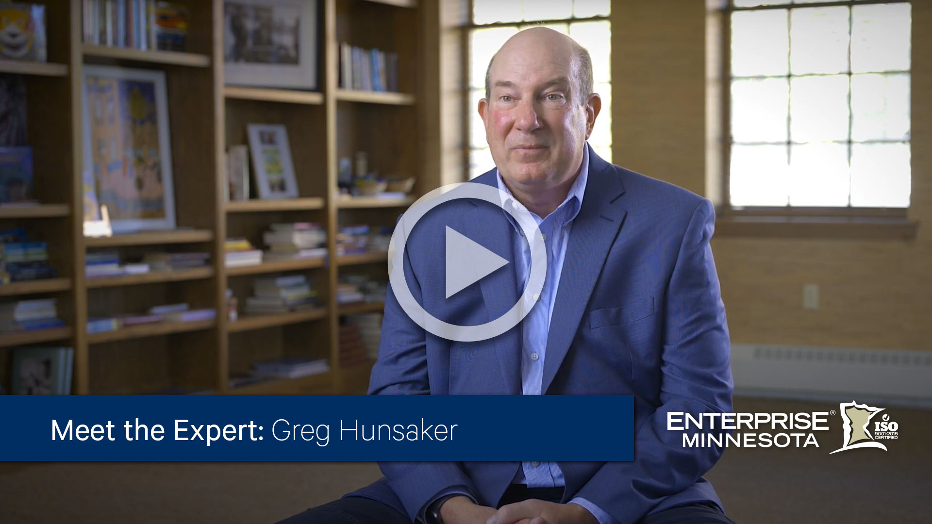 Greg Hunsaker sitting in a chair. Click to watch his bio video. 