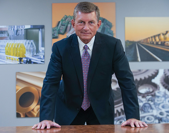 Seacole CEO Gregg Elliott standing in front of company photos.