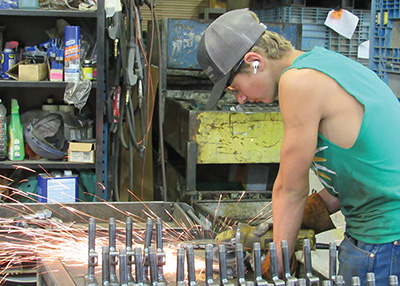 Worker fabricating metal parts at Machinewell.