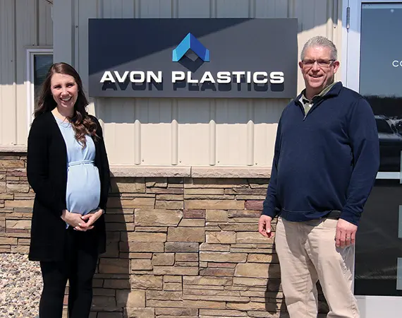 Owners of Avon Plastics standing outside their shop.