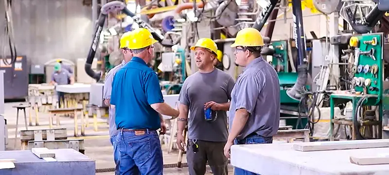 Chaplain speaking to manufacturing workers on the production floor