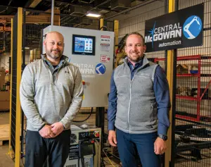 Central McGowan owners standing in front of a manufacturing machine.