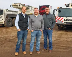 Landwehr leaders standing in front of machinery