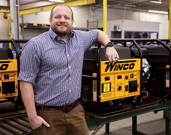 Winco owner/CEO Dan Call standing with a branded generator.