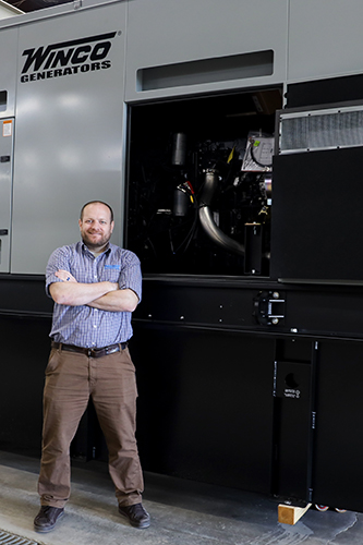 WINCO owner Dan Call standing next to a large gray generator