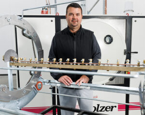 Kolzer International co-owner Robert Doty stands beside a Kolzer PVD coating machine at the company's newly opened Maple Grove, Minnesota facility.