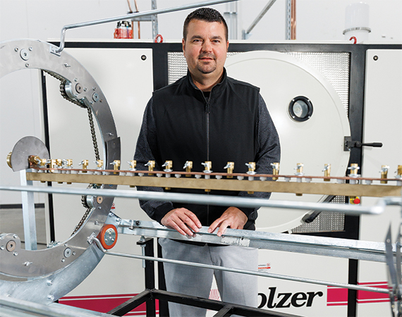 Kolzer International co-owner Robert Doty stands beside a Kolzer PVD coating machine at the company's newly opened Maple Grove, Minnesota facility.