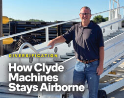 Chad Barsness, president of Clyde Machines, standing beside an airline passenger boarding stairway at the company's facility.