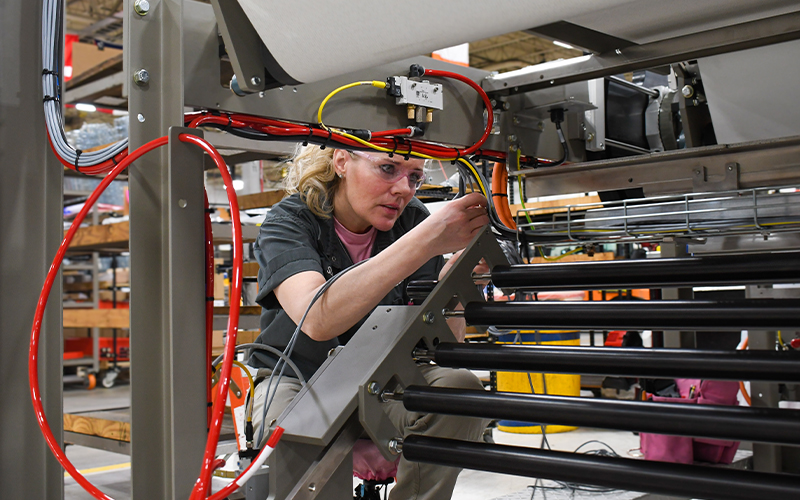 A Douglas Machine employee assembling a secondary packaging machine.