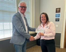Mark O'Leary presenting Amy Thimmesh with the Esteemed Colleague award, shaking hands.