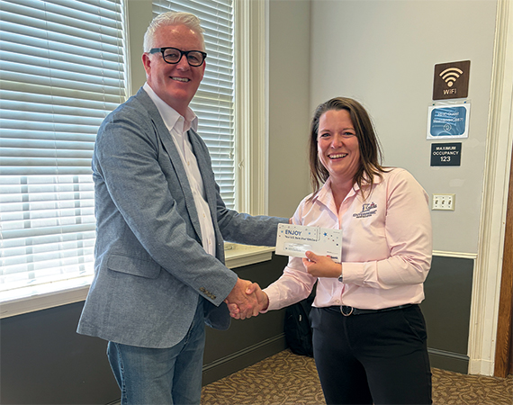 Mark O'Leary presenting Amy Thimmesh with the Esteemed Colleague award, shaking hands.