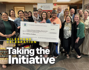 Northwest Minnesota Foundation staff and partners holding a ceremonial $2 million check from the U.S. Department of Housing and Urban Development.